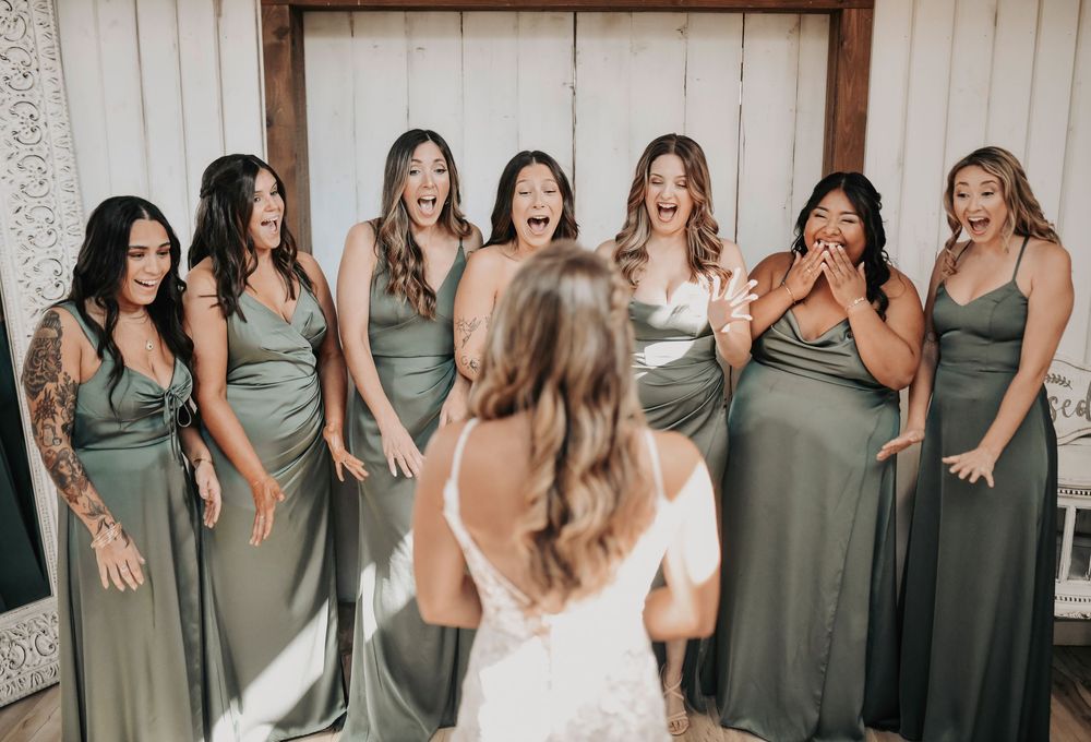 Fun candid bridesmaid first look with olive green dresses and boho bouquets