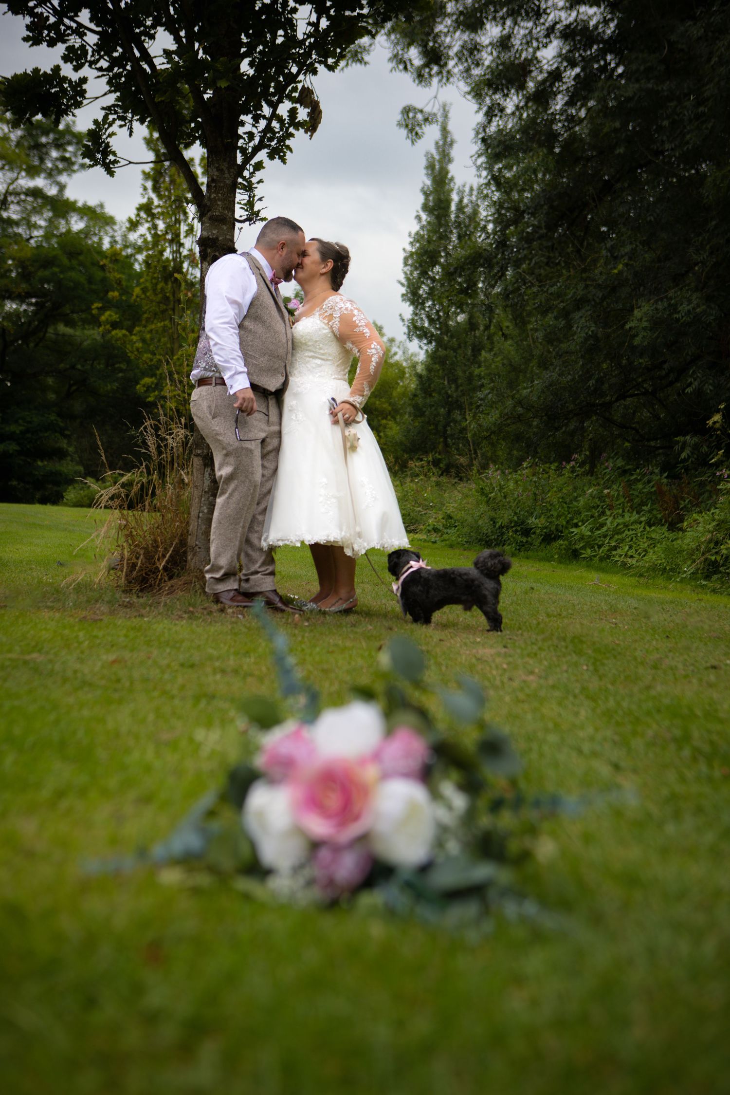 A romantic black and white photo series showing intimate moments between newlyweds in a garden setting.