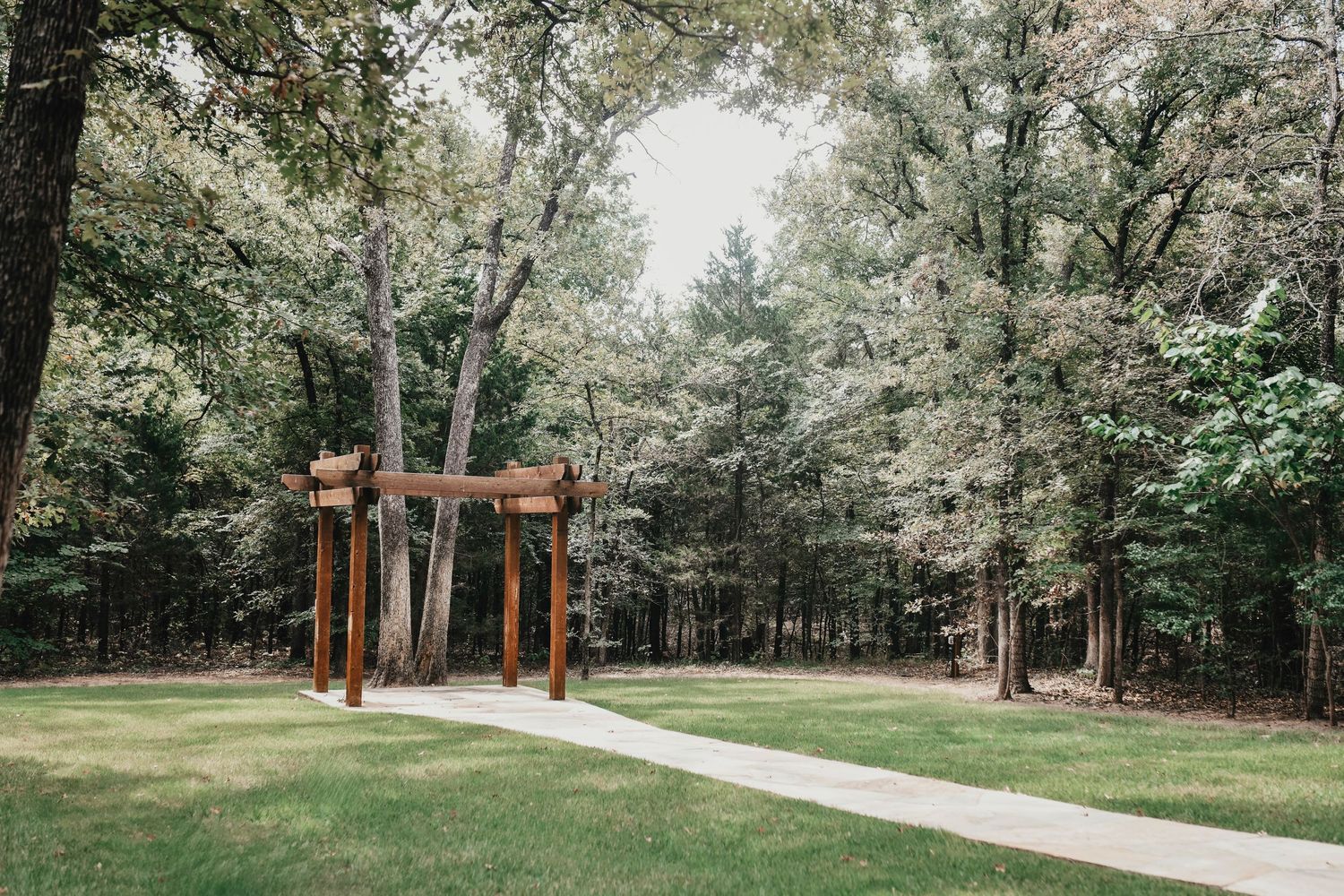 Rustic wooden bridge surrounded by greenery for outdoor wedding portraits in valley view at the whispering oaks wedding venue