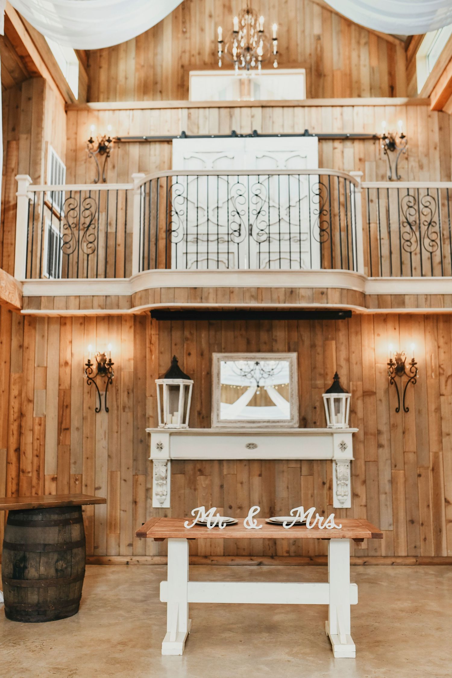 Elegant white barn interior filled with sunshine and soft, flowing curtains inside the modern barn of whispering oaks in valley view, tx