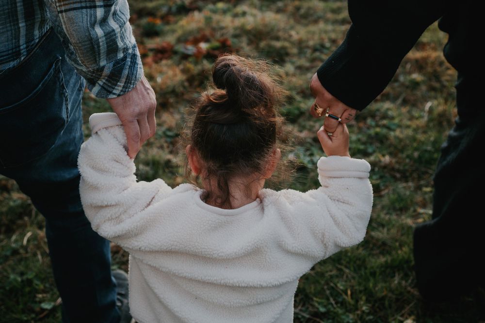 Une petite fille avec ses parents lors d'une séance photo en montagne aux Carroz, photographe mariage et lifestyle.