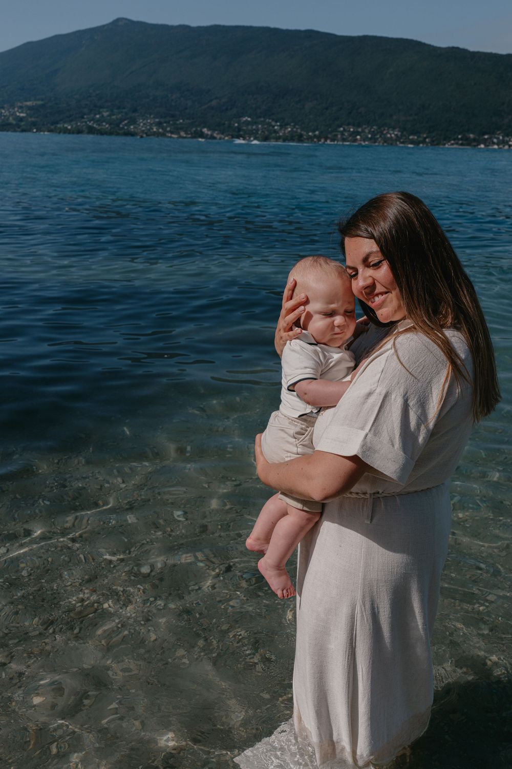 Une maman et son bébé dans un moment tendre lors d'une séance photo famille au bord du lac d'Annecy, photographe famille et mariage Annecy.