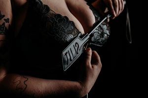 Close-up shot of hands working on a detailed illustration with black ink on white paper. Grand Rapids Boudoir Photography