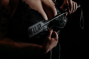 A person's hands insert and connect audio cables into a headphone jack panel. Grand Rapids Boudoir Photography