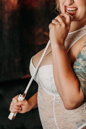 Bride in white lace dress smiles while applying perfume in a series of close-up shots. Grand Rapids Boudoir Photography