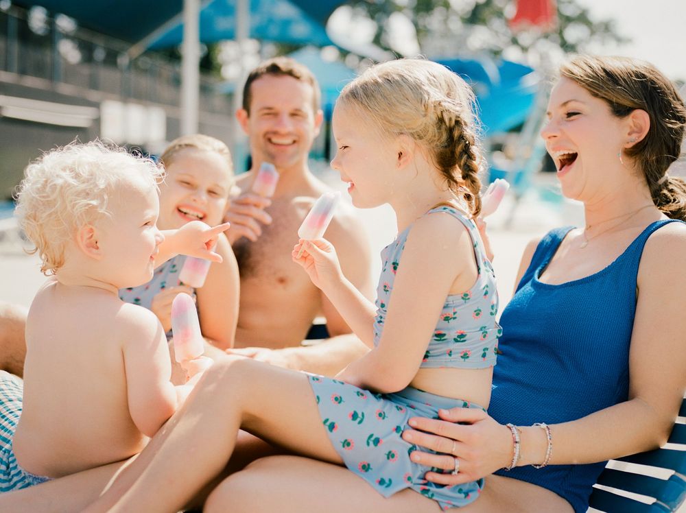 Group enjoying a sunny pool day wearing blue and white swimwear.