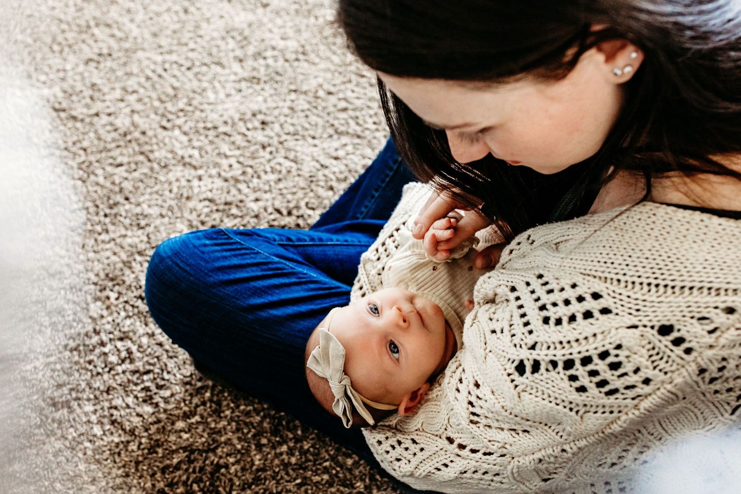 Baby gazes up at mother.