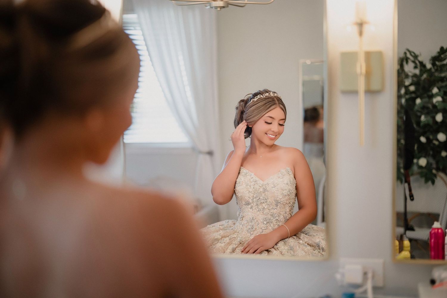 Getting ready scene with bridesmaids in silk robes helping with wedding preparations.