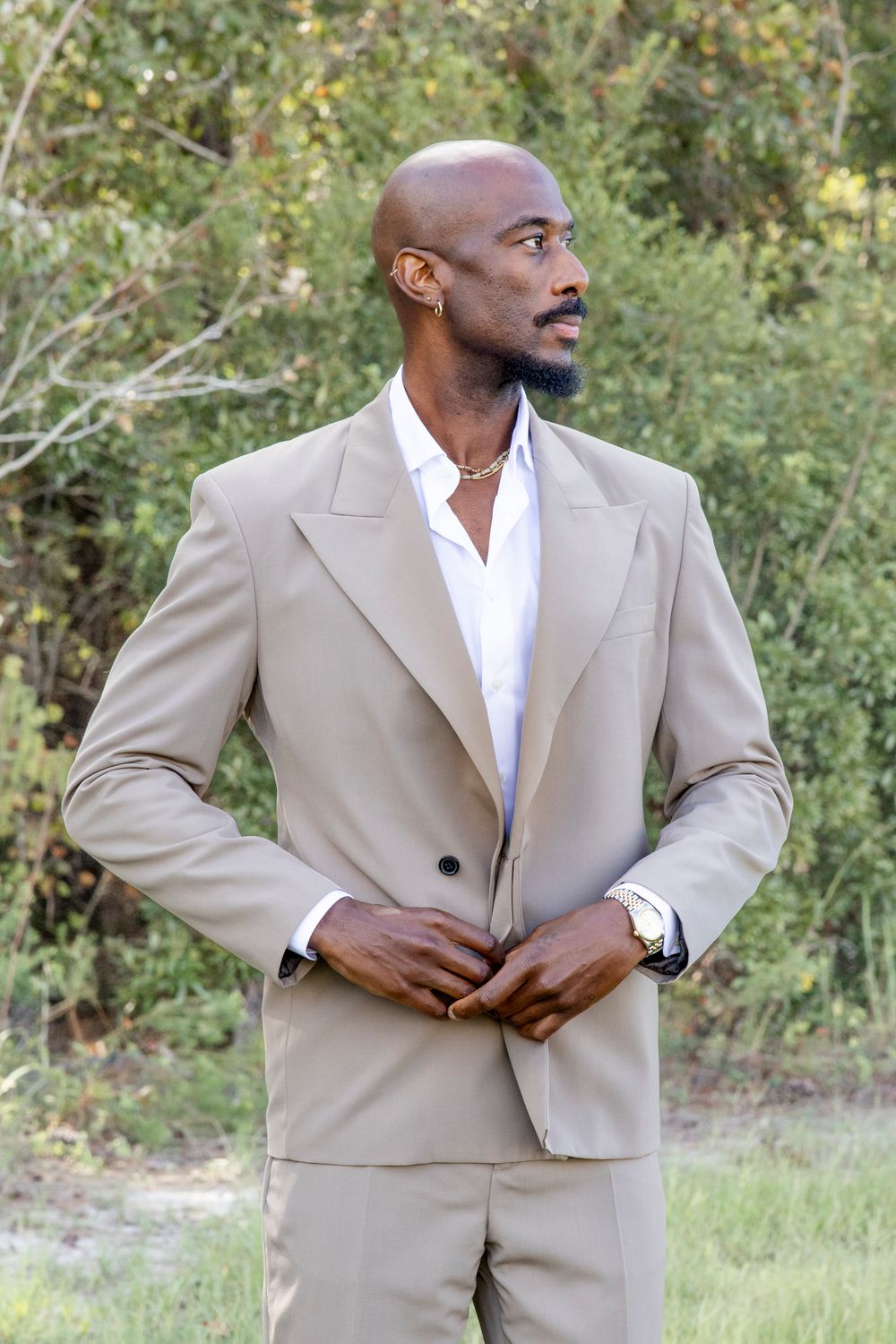 Luxury Austin groom adjusting boutonniere with natural, expressive style