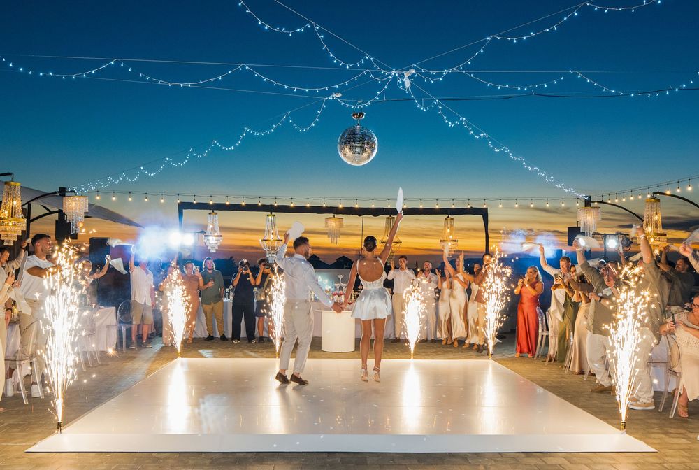 A wedding reception with a stunning fireworks display on a large outdoor patio at night at Conrad Bali Resort.