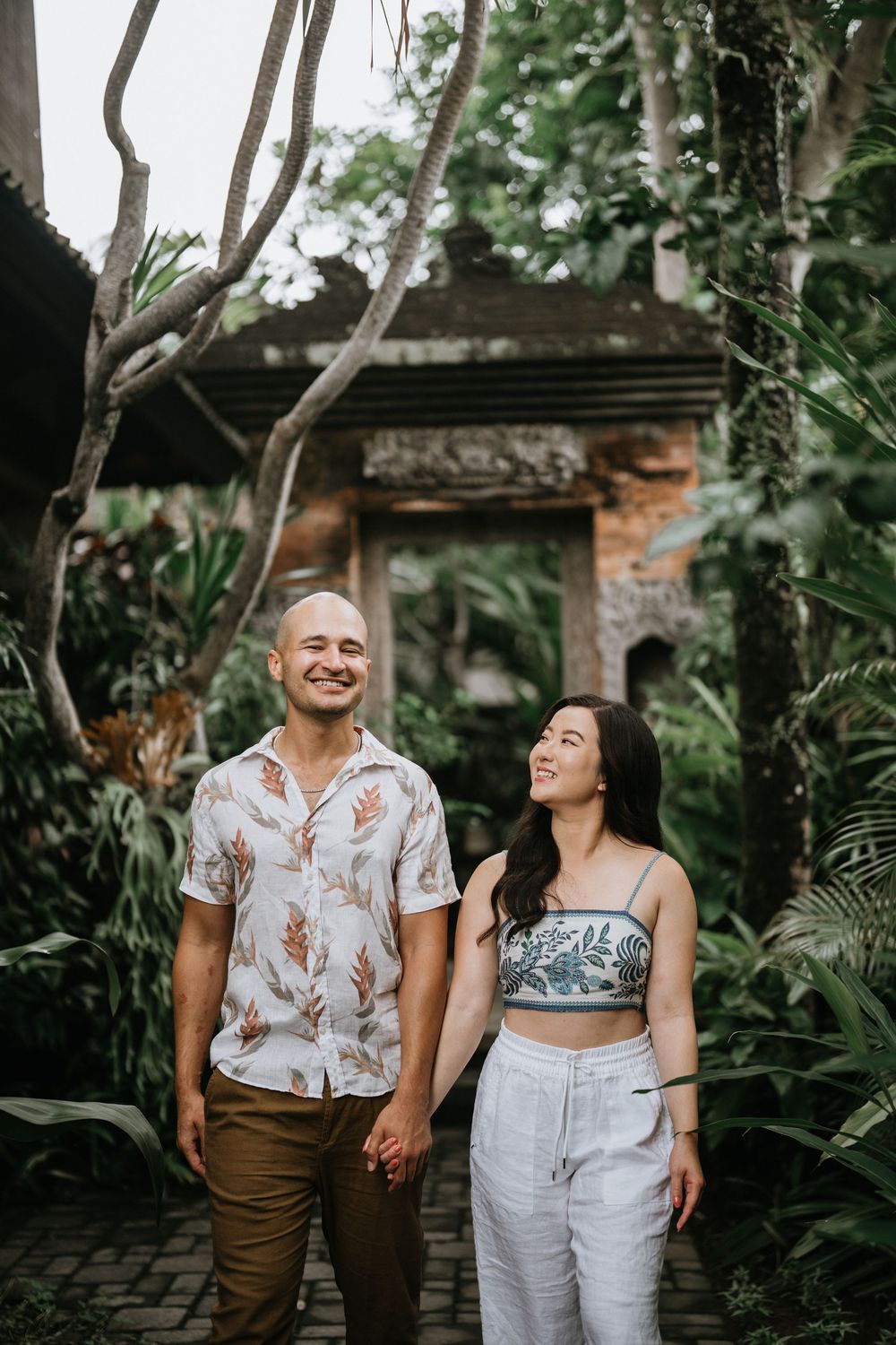 Couple sharing a joyful moment in a lush Balinese garden setting.