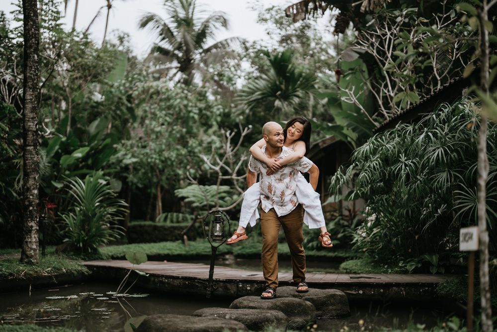 Fun outdoor photoshoot in a tropical garden with wooden walkways and palm trees.