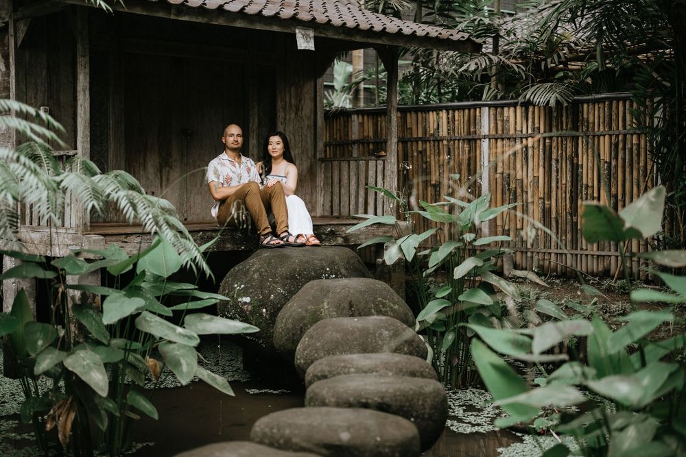 Romantic photoshoot in a traditional Balinese garden setting with bamboo structures.