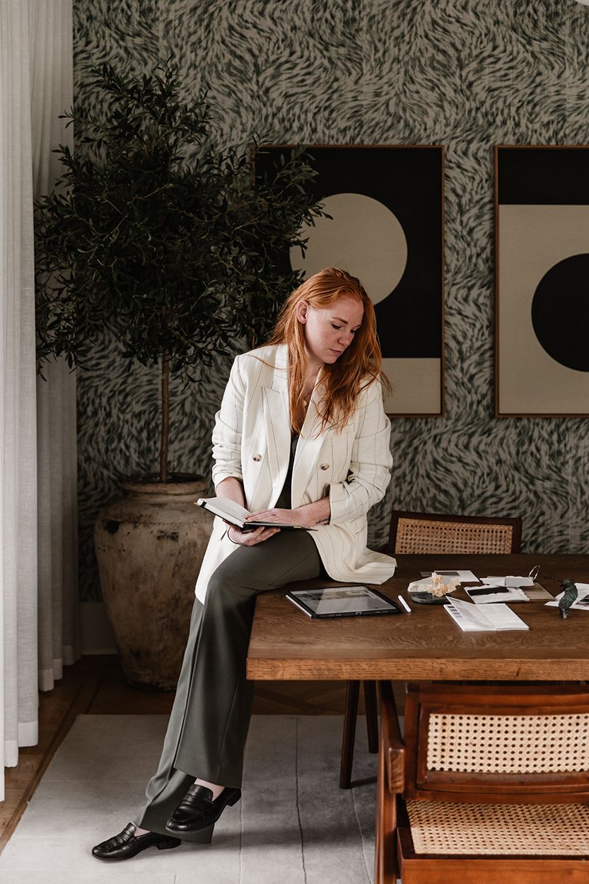 Interieurontwerper in een huiselijke ruimte met stralen voor zich en werkspullen voor een zakelijke fotoshoot.