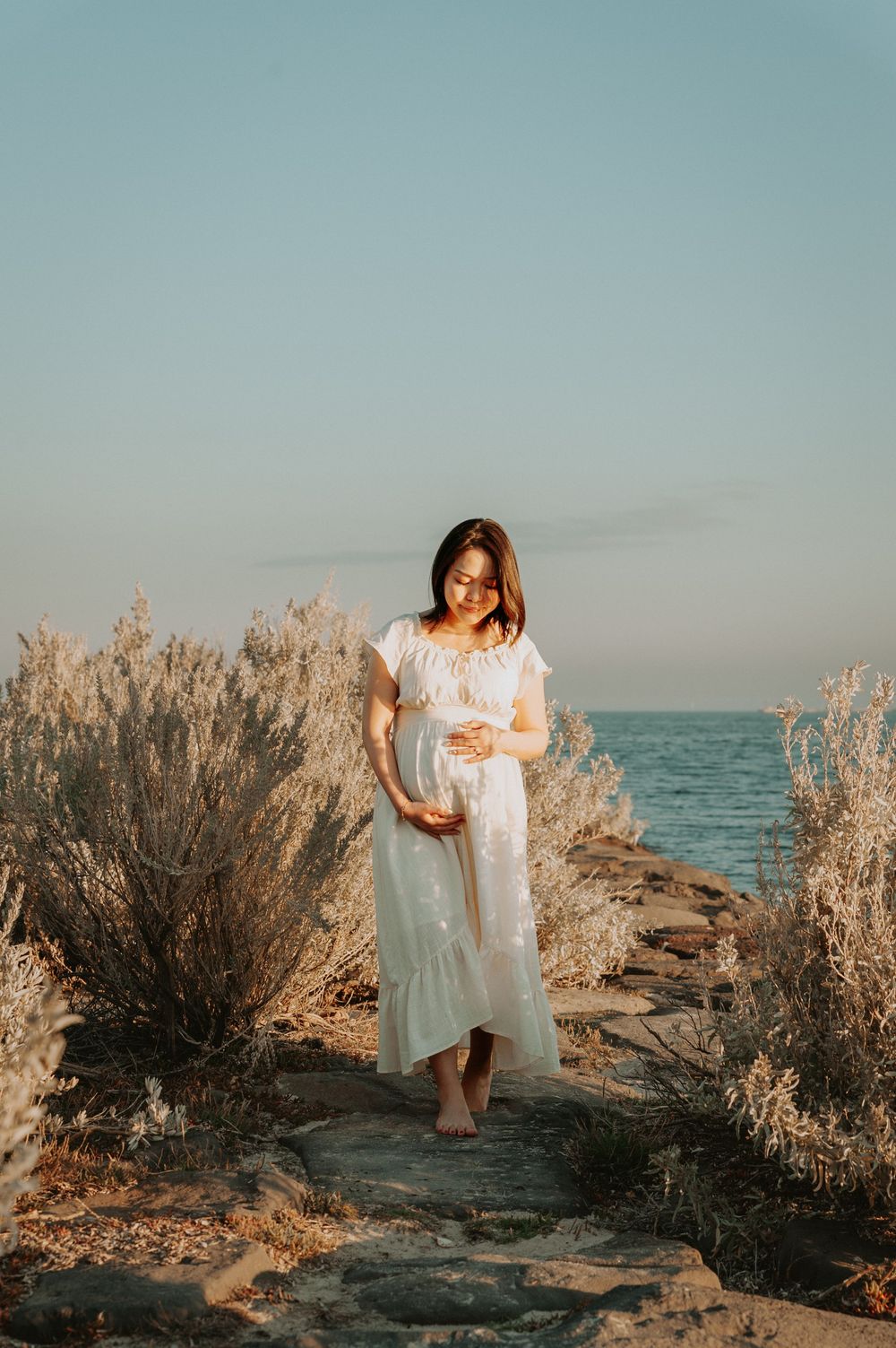 A maternity photo session on the beach with golden shrubs and path, in soft sunlight.
Altona Maternity Photographer Melbourne