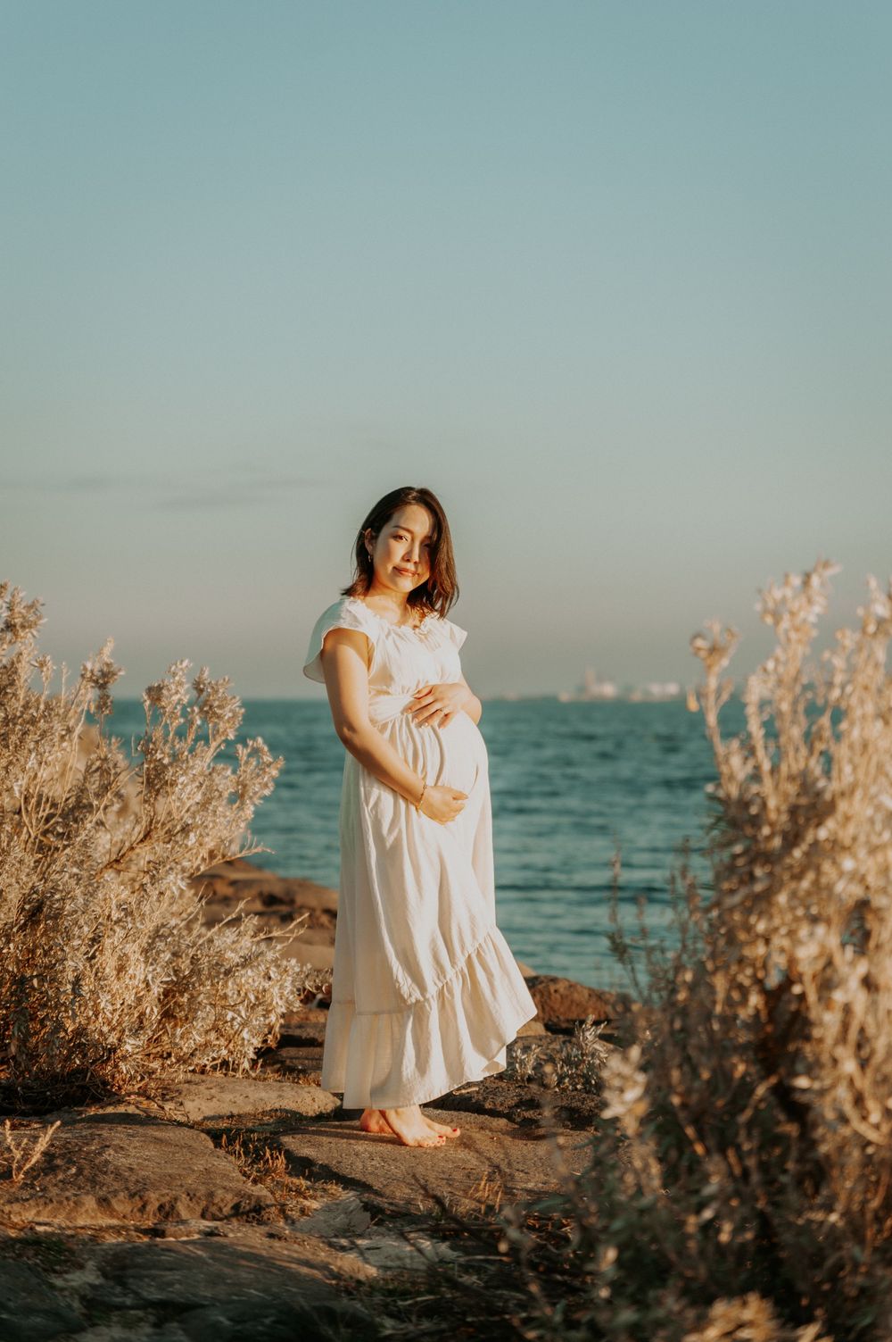 A maternity photo session on the beach with golden shrubs and path, in soft sunlight.
Altona Maternity Photographer Melbourne
