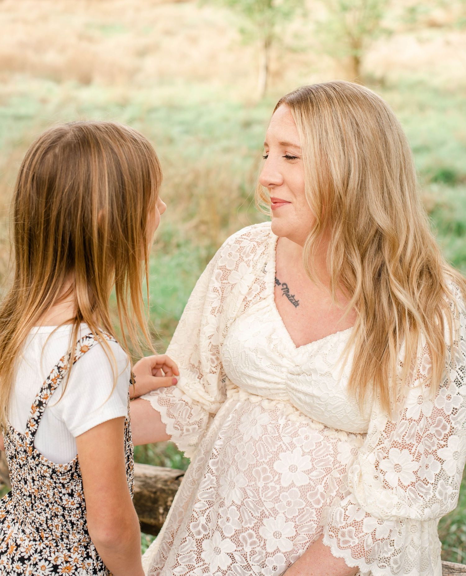 A series of candid moments captured between two people in white lace dresses sitting together outdoors.