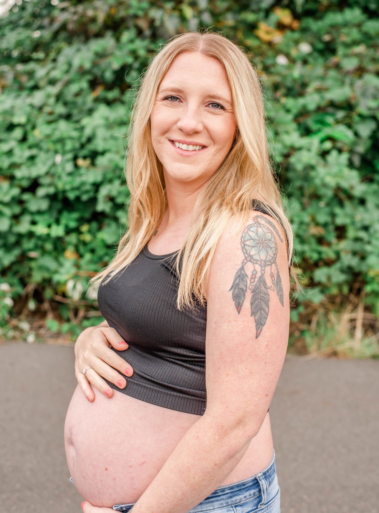 Outdoor portrait series featuring person in black top with dreamcatcher arm tattoo against green foliage.