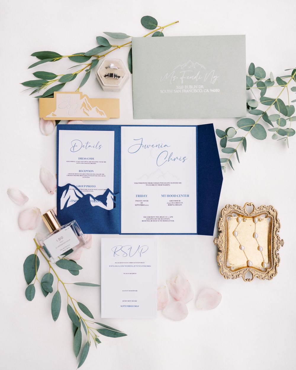 Navy blue wedding invitation suite with gold frame and eucalyptus styling.
