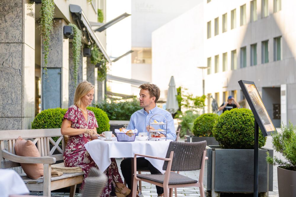 A couple dining al fresco at an elegant outdoor restaurant table.