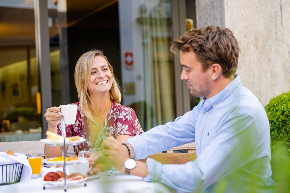 A couple shares laughter during an outdoor dining experience.