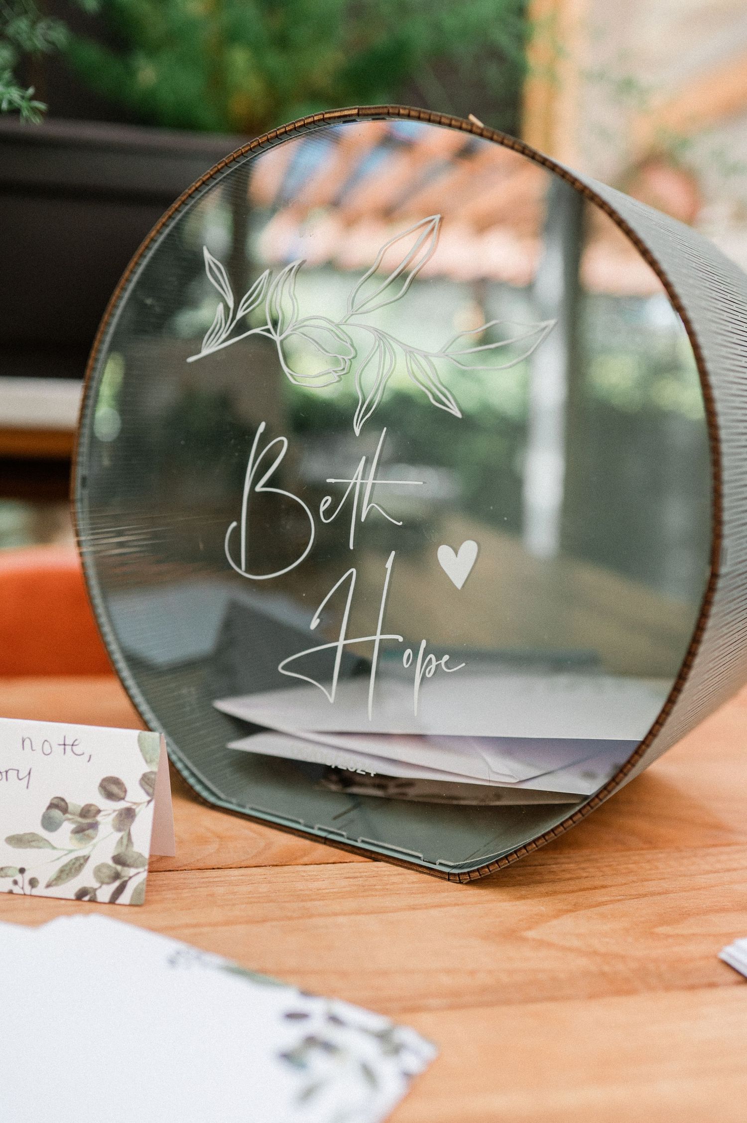 Glass box that holds cards sits on a wooden table