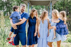 Group poses together outdoors wearing coordinated blue and white outfits.