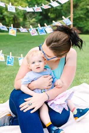 A series of outdoor photos with string photo decorations and blue and white baby-themed party decor.