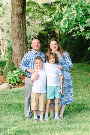 A series of four outdoor family portrait photographs showing joyful moments between family members in a green backyard setting.