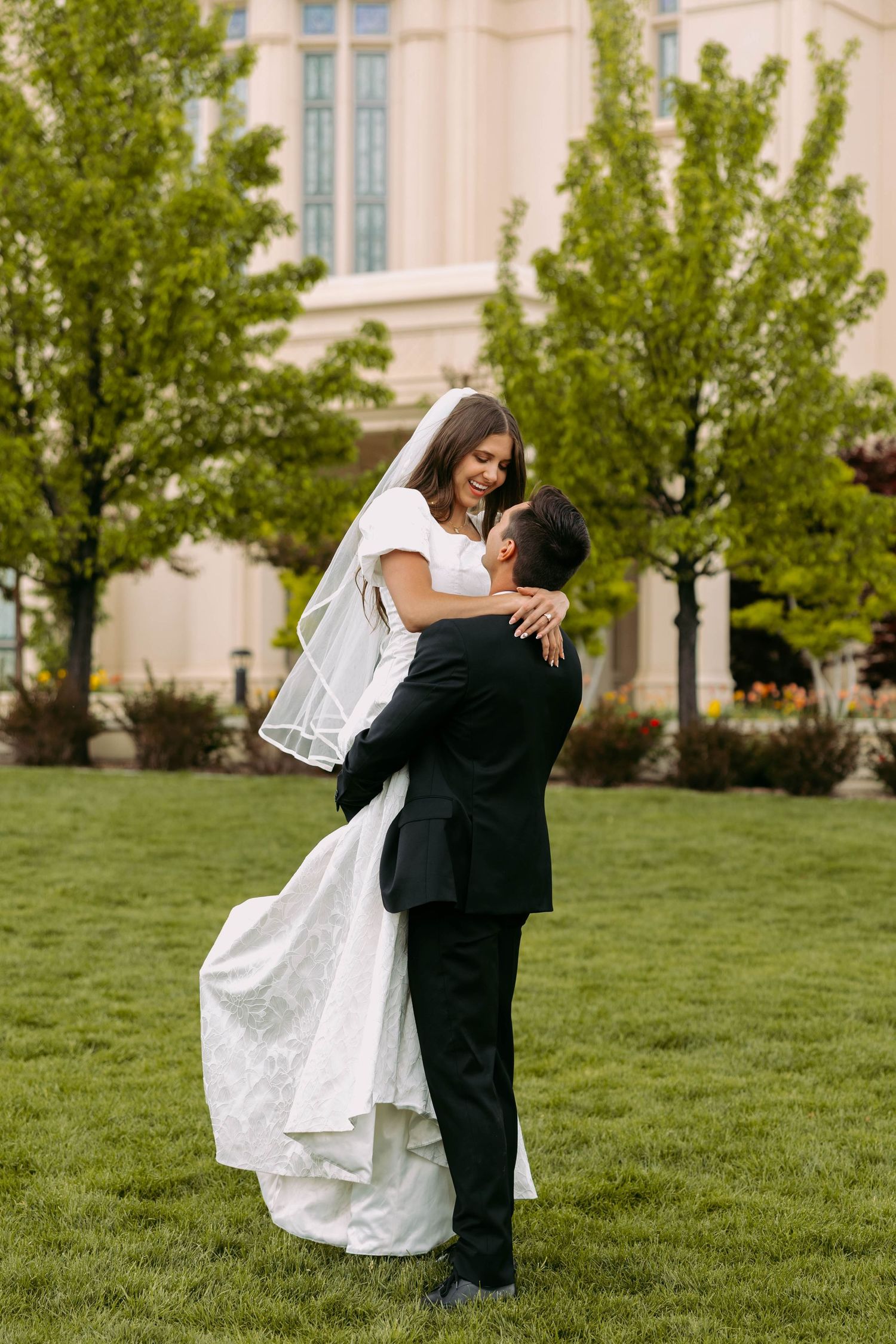 Romantic couple embraces against mountain backdrop during golden hour photoshoot.