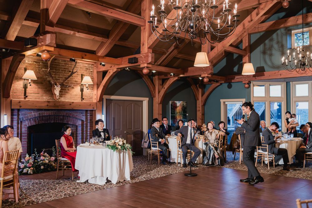 A rustic timber-framed wedding reception venue with elegant chandeliers and guests gathered for a celebration at TRapp Family Lodge in Stowe