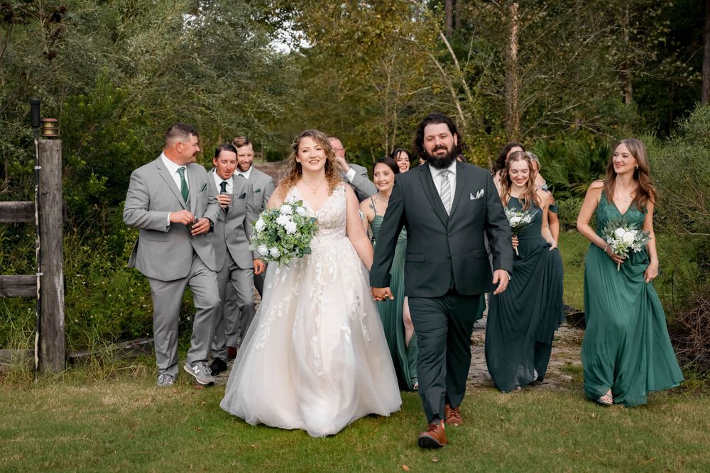 Wedding party in green and gray attire walking outdoors during celebration.