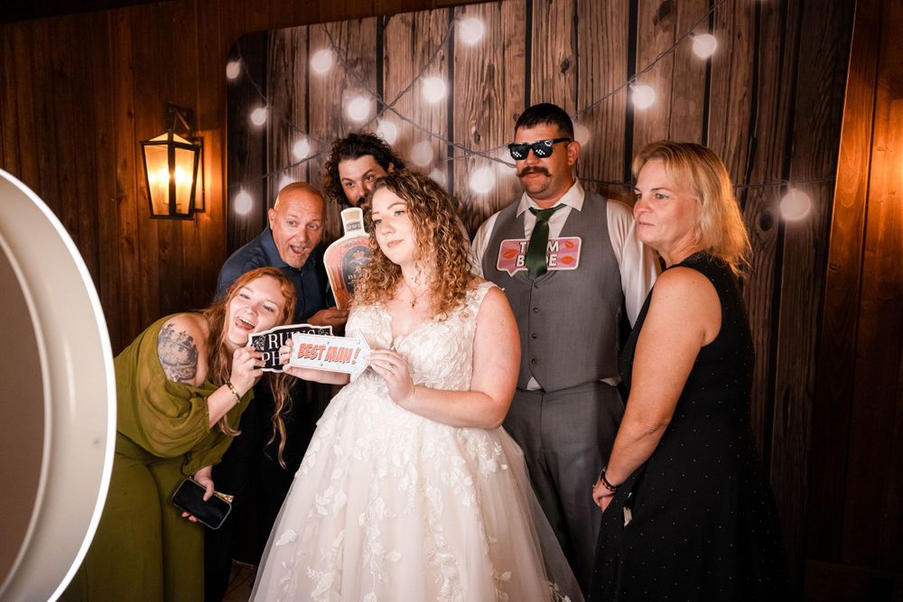 Wedding guests celebrate with silly poses and props during a photo session.