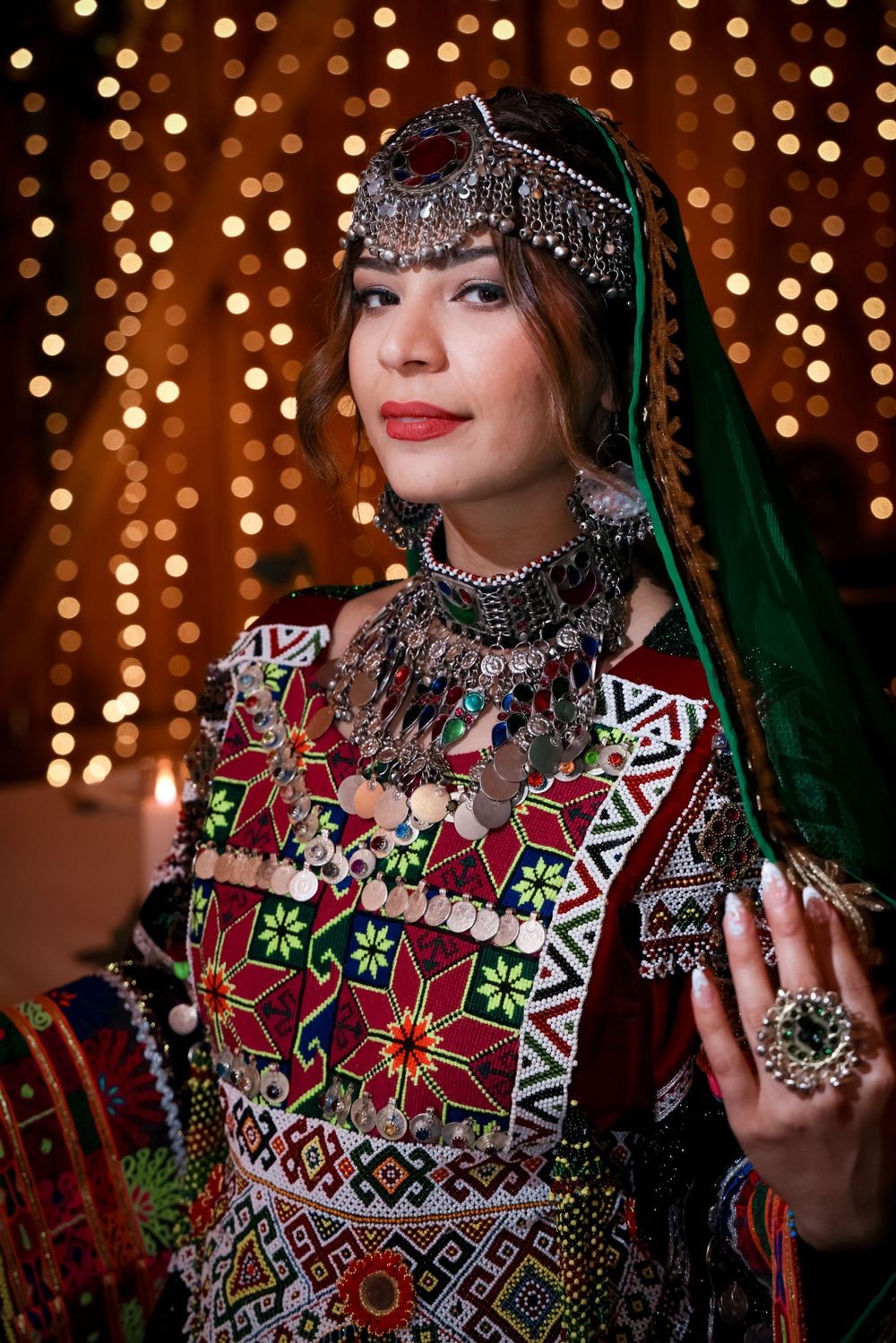 Traditional ethnic dress with ornate beadwork and embroidery against a bokeh light background.