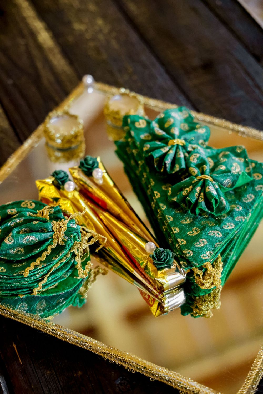 Ornate green and gold traditional Afghan dress accessories displayed on golden tray.