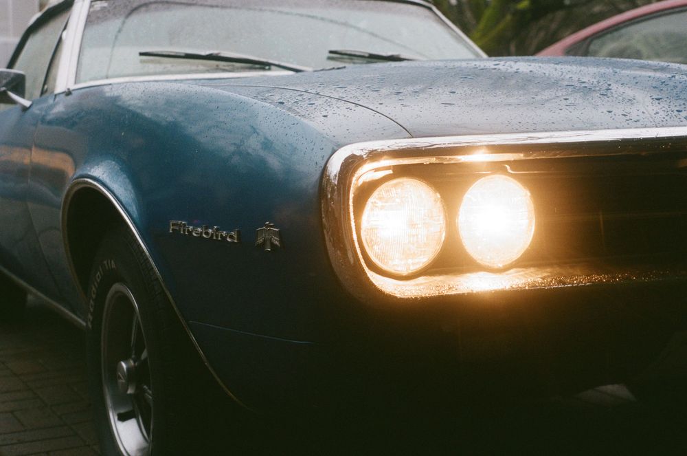 Close-up view of modern car headlights glowing in the dark.