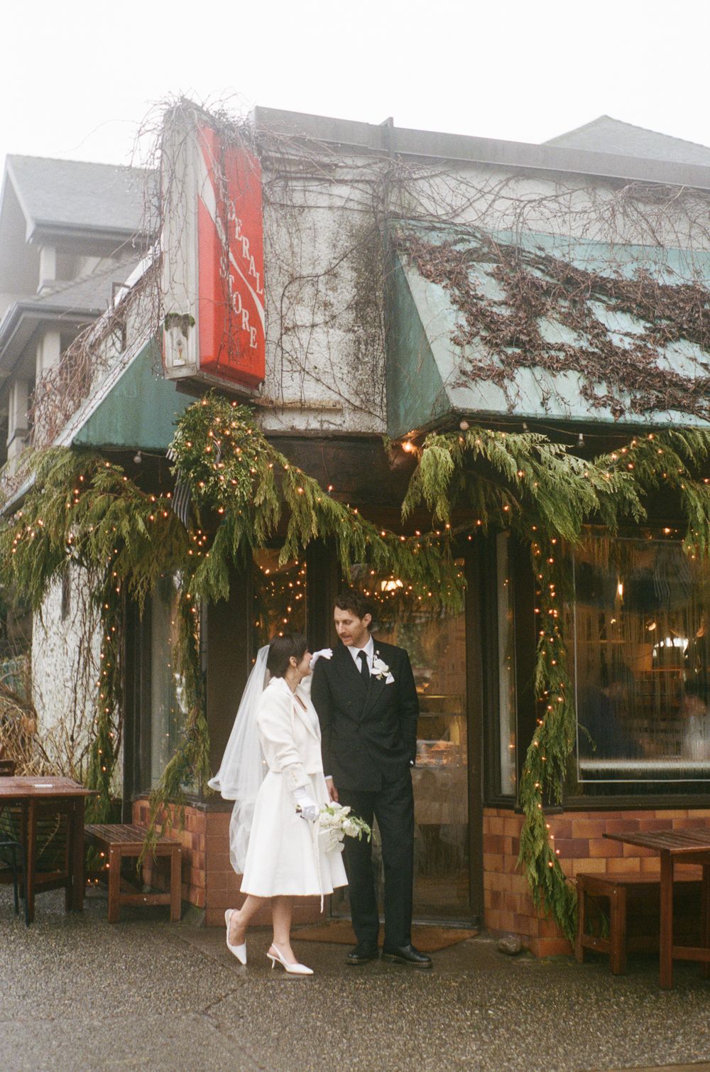 Wedding venue exterior decorated with evergreen garlands and twinkling lights.