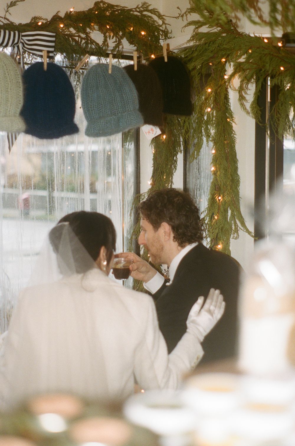 Wedding reception venue decorated with hanging greenery and twinkling lights creating an intimate atmosphere.