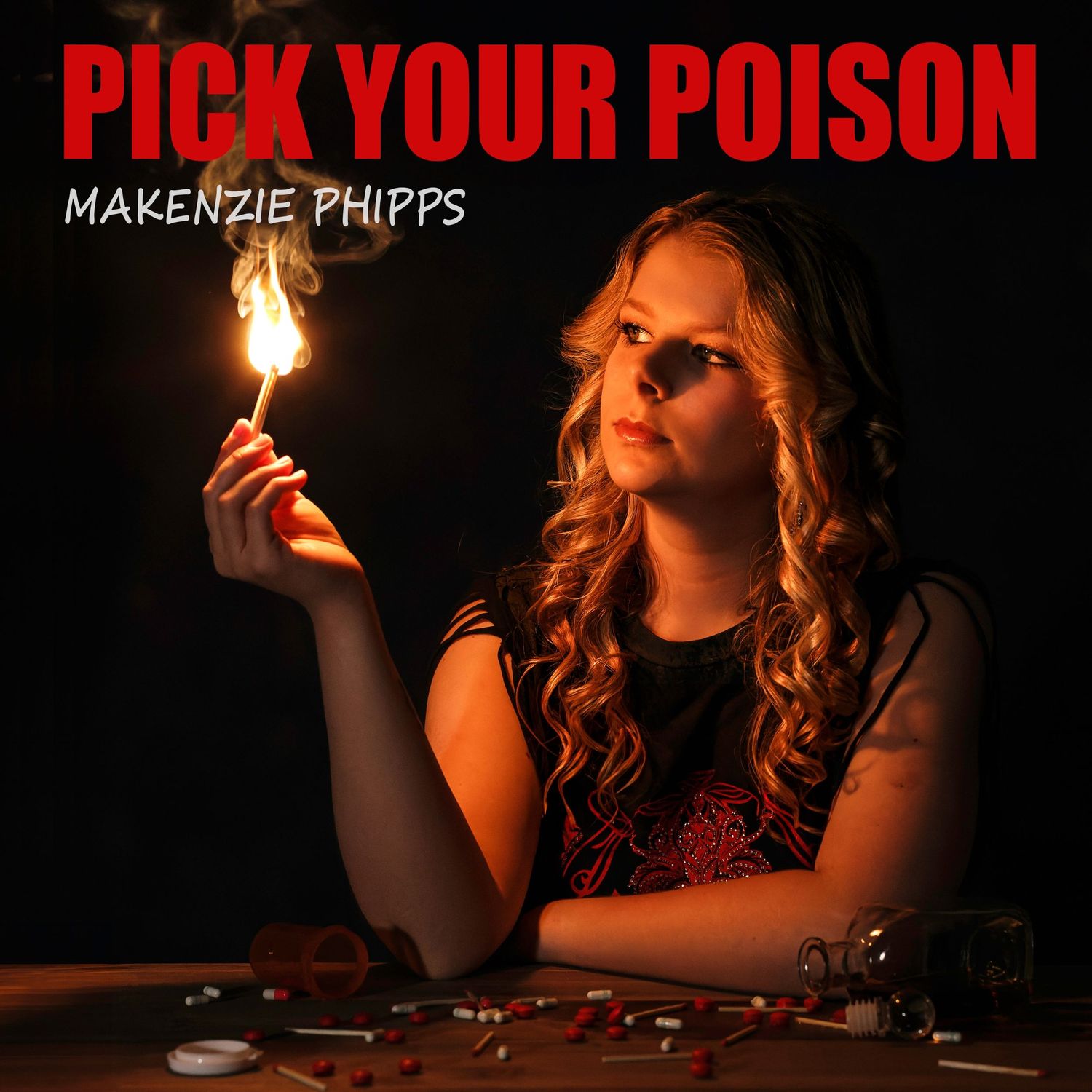 Album cover art for Makenzie Phipps featuring dramatic lighting and flame against dark background.
