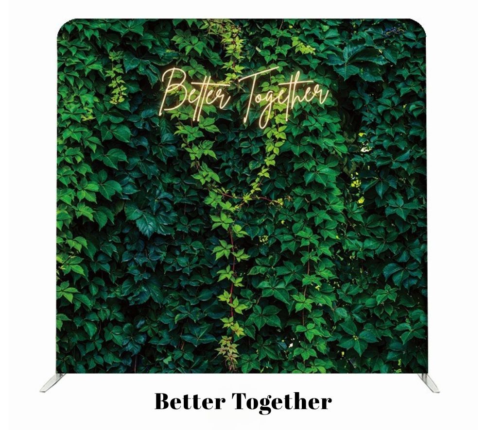 Neon sign reading 'Better Together' illuminates a lush green ivy wall backdrop for a photo booth display.