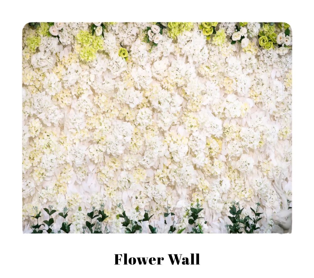 Luxurious white floral wall installation with lush greenery accents creating an elegant event backdrop.