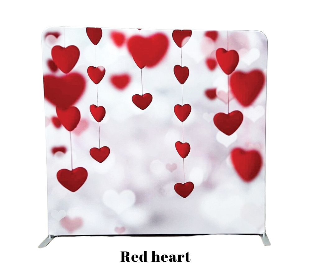 Red heart shaped decorations hanging against blurry white background in romantic Valentine's Day display.