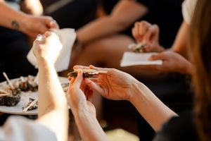 Close up hands rolled cigarette smoking session at gathering.