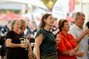 A group of people enjoying drinks and festivities at an outdoor event with a joyful atmosphere.