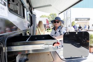 Food truck vendor operating equipment at an outdoor festival or market event.