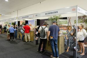 Visitors browsing displays and exhibits at an indoor trade show or exhibition event.