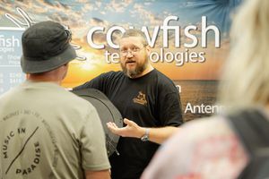 Crowded booth with Crayfish Technologies banner display at a trade show or event.