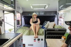Interior view of a modern camper van showing bench seating and storage compartments with green accents.