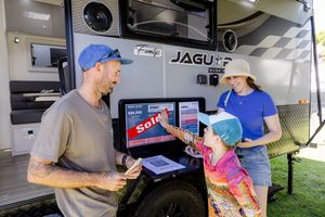 Customers ordering from food truck window at outdoor event.