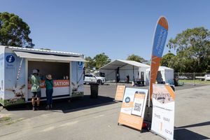 Food trucks and vendor setups at an outdoor marina event with banners and signage.